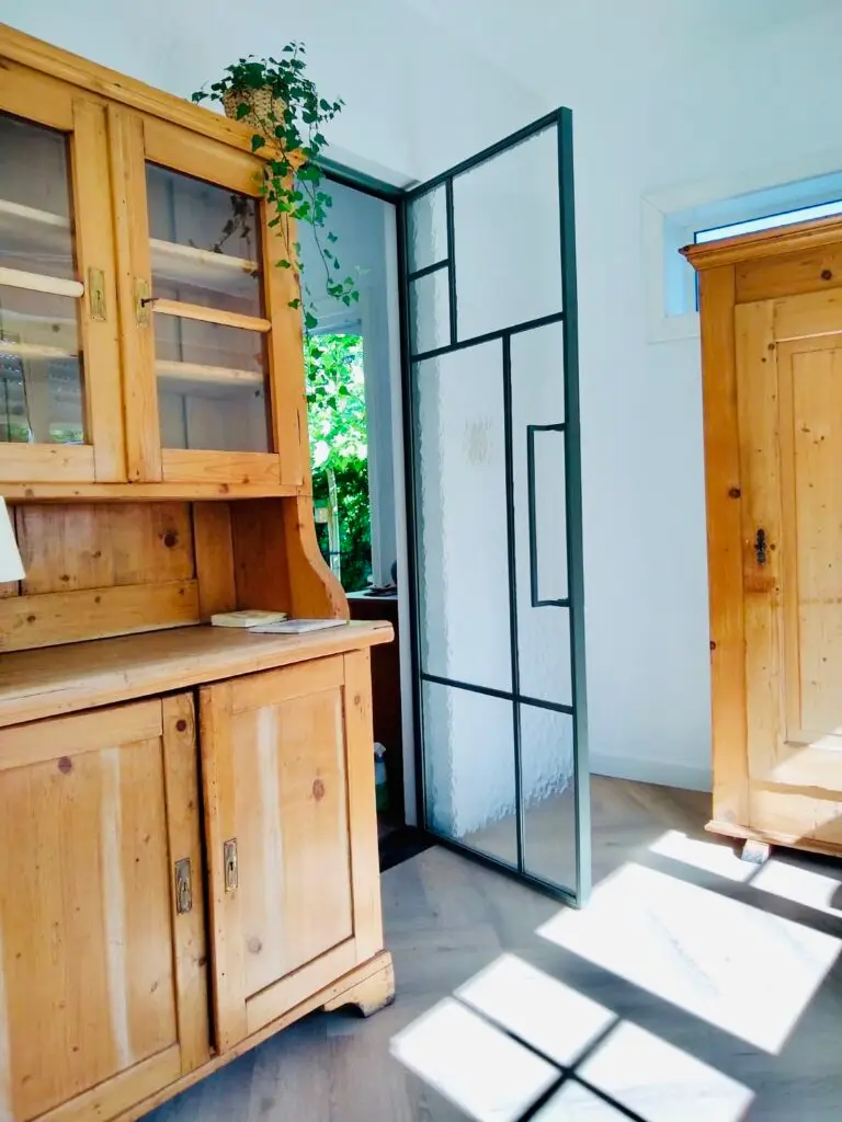 Stalen binnendeur naast een houten kast